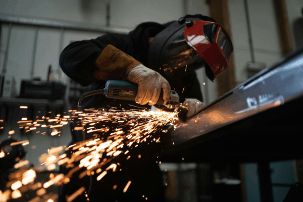 A welder welding in a manufacturing plant