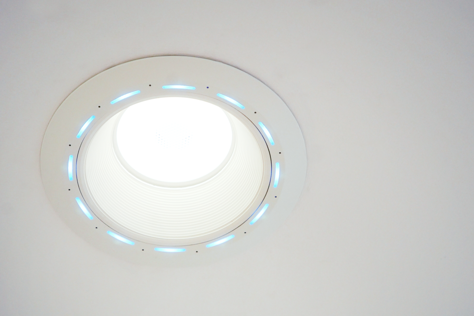 Looking up at Juno AI recessed LED ceiling fixture with cyan accent ring detail